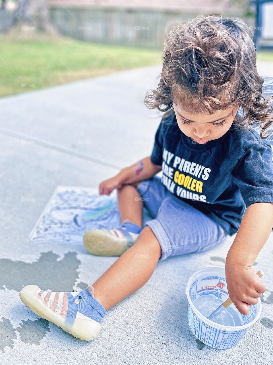 Toddler girl paints outside in the summertime, crafts with toddlers, magic painting with toddler, toddler girl have fun making art outside 