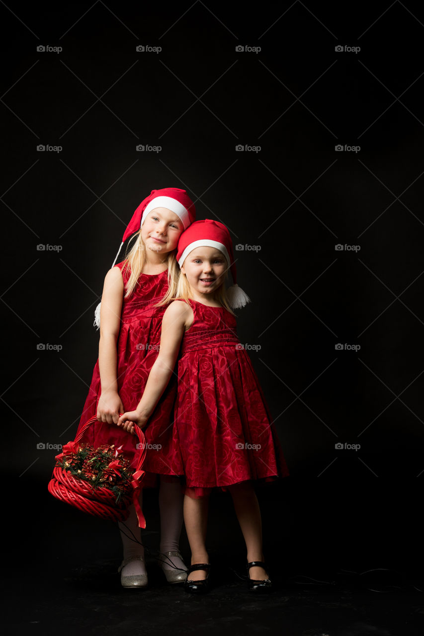 Two sisters posing for christmas portrait.