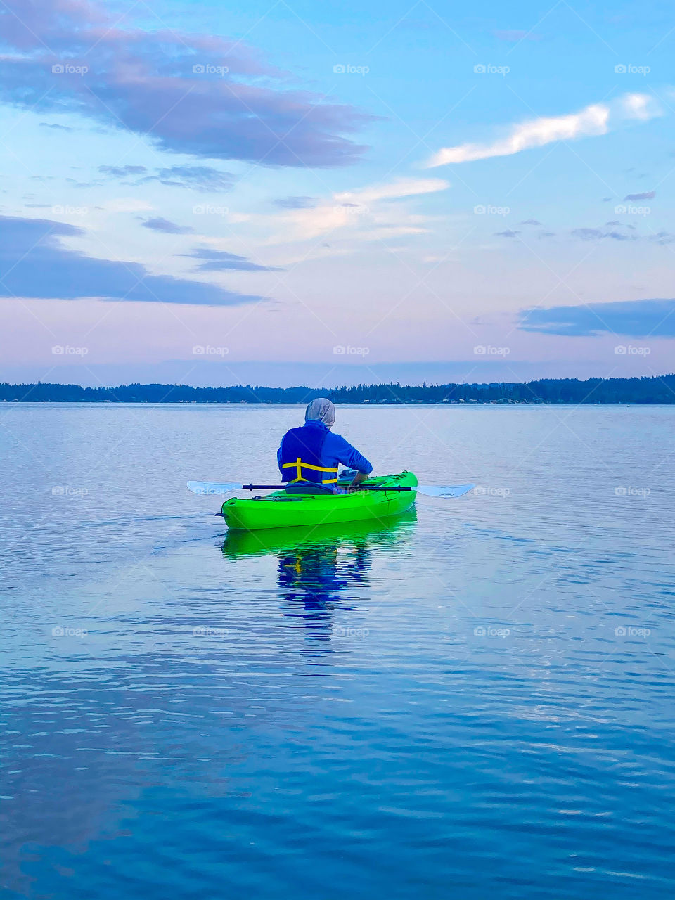 Kayaker on the water for an evening sunset paddle in Puget Sound, Washington 