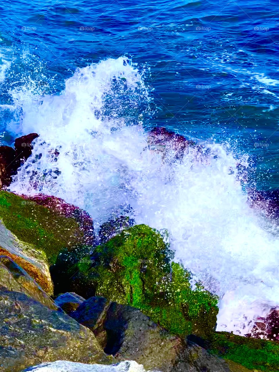close shot of ocean waves hitting rocks on the shore