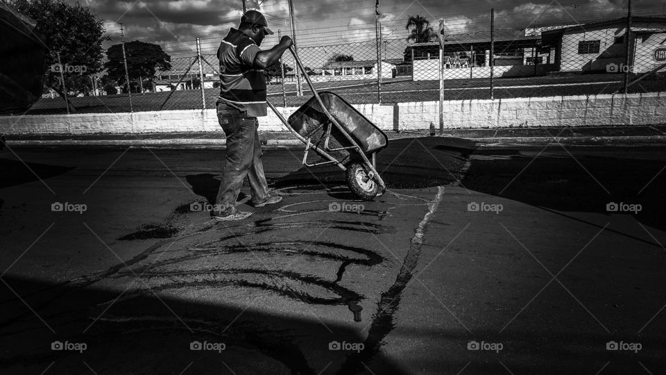Homens trabalhando em asfalto. Prefeitura em obras.
