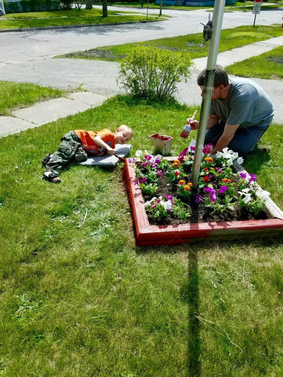 Helping papa paint the flower bed 