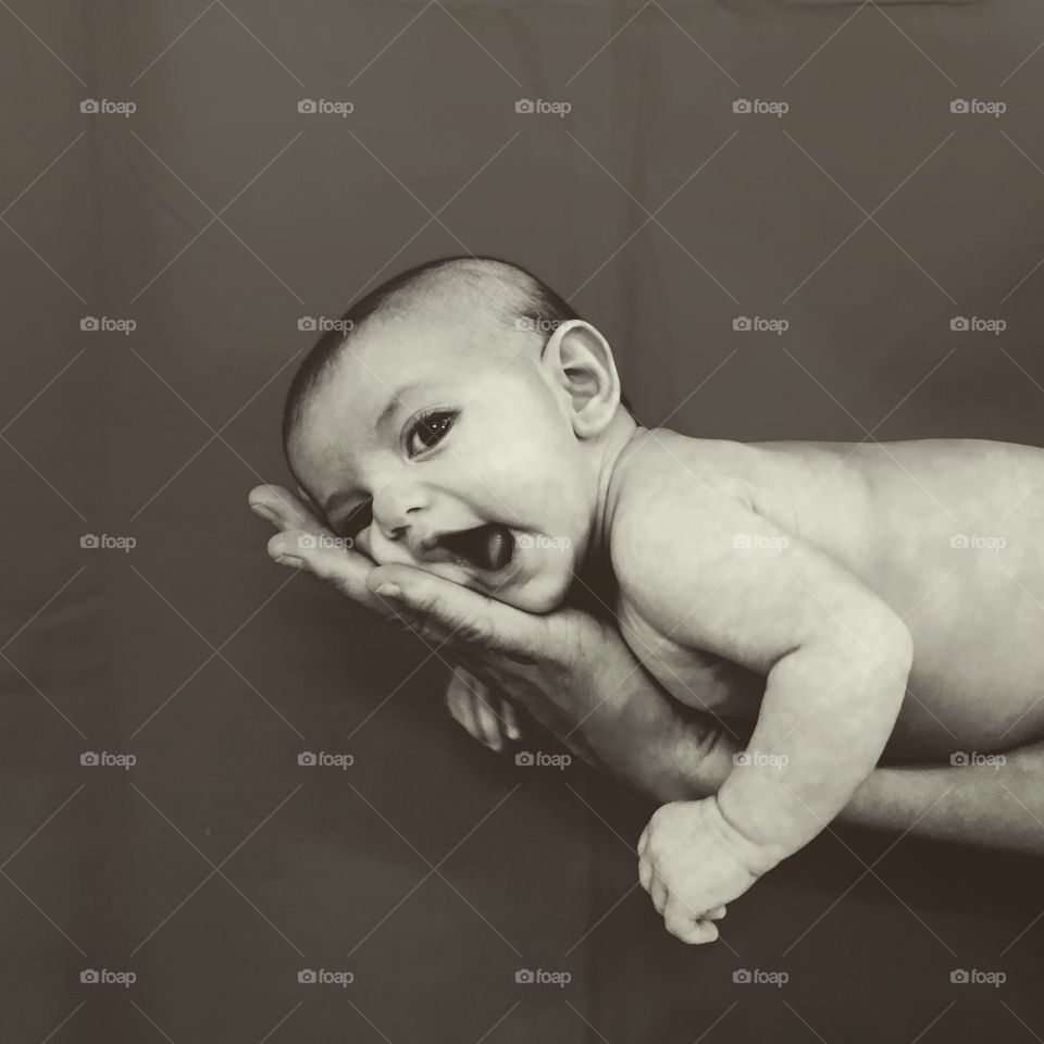 Baby boy lying on palm of hand