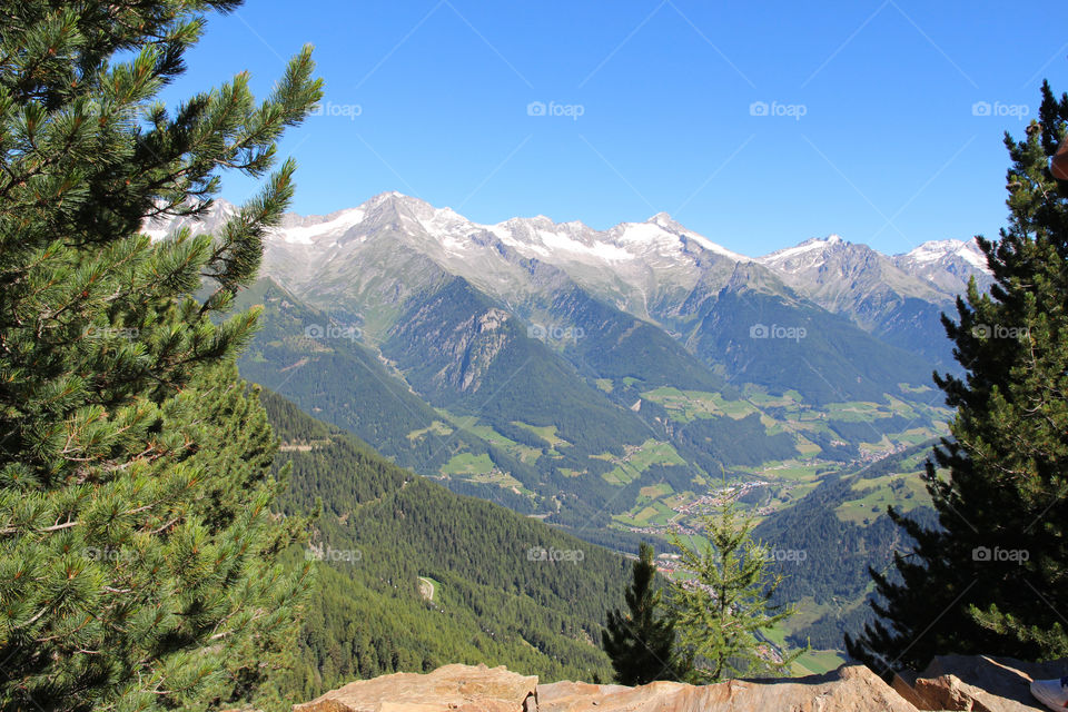 Hiking trail at high altitude, view of valley and snowy mountain peaks 