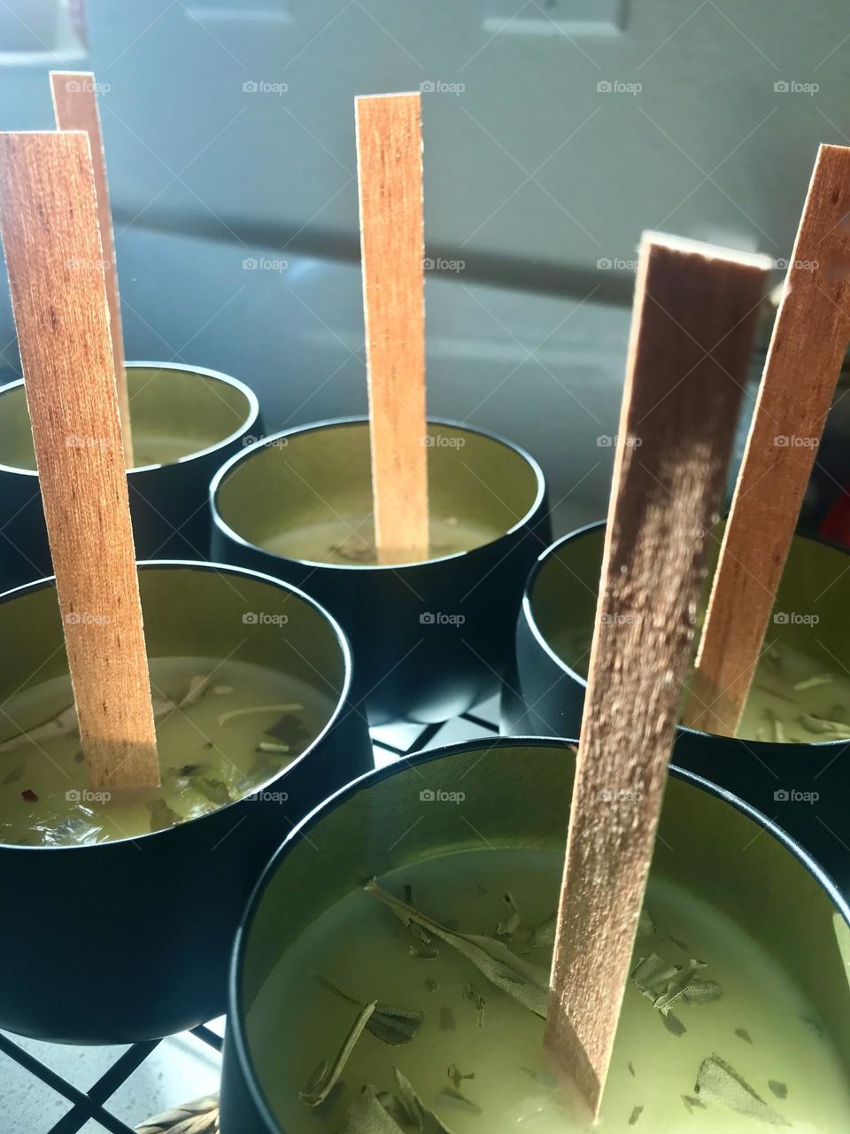 Close up of candles being made with wood wicks, soy wax, and dried flowers
