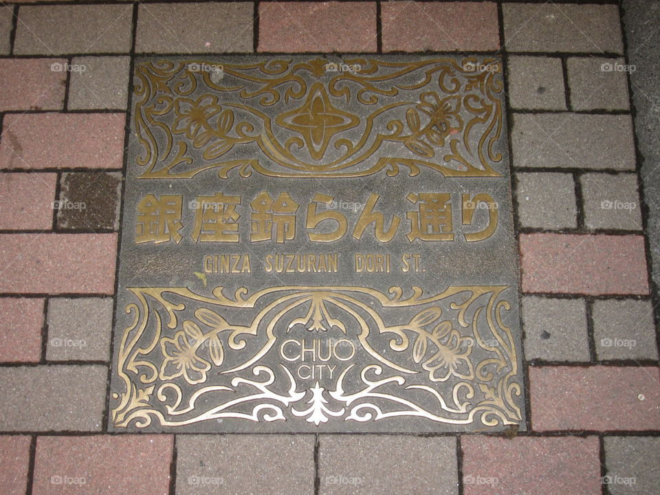 Ginza, Tokyo, Japan. Suzuran Dori.  Ornate Sewer Manhole Cover on Street.