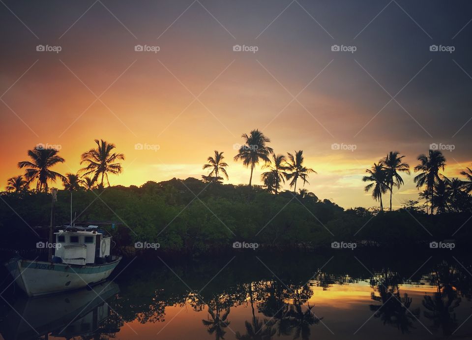 Sunset with a boat in Brazilian beach in Bahia 