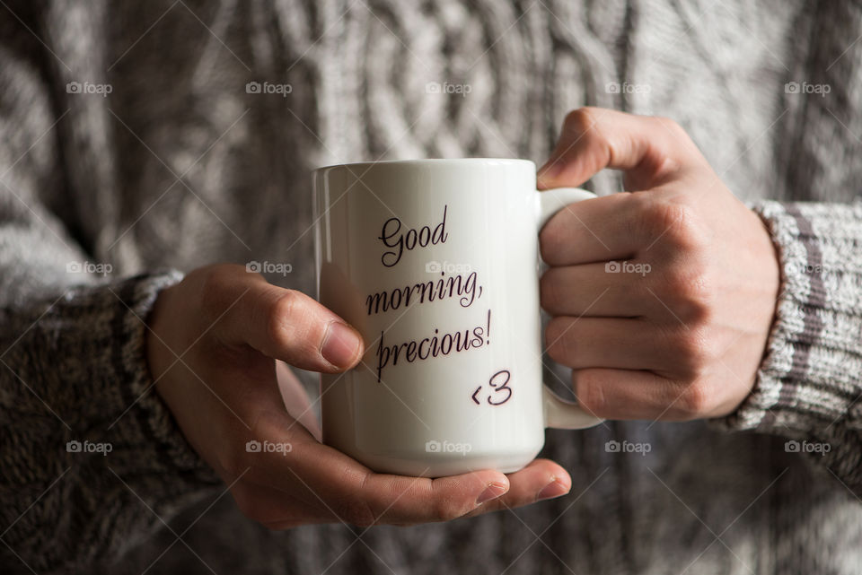 Close of hands holding big cup of coffee