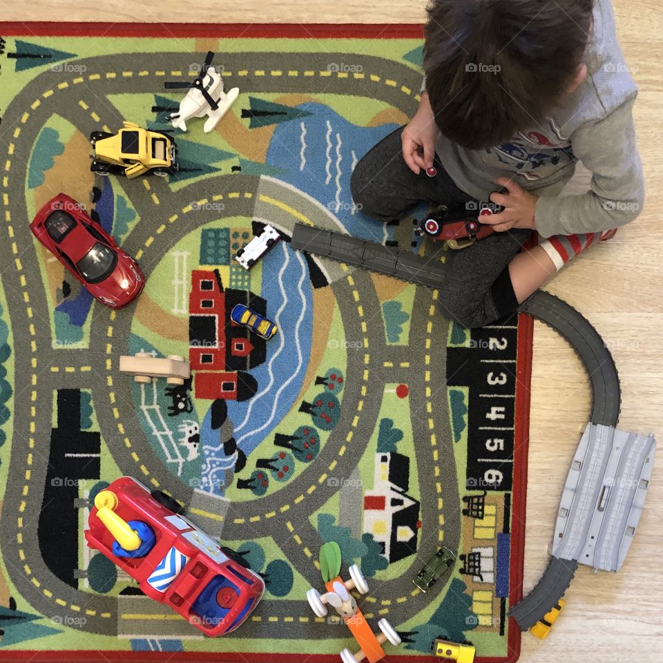 Toddler playing with cars on the floor