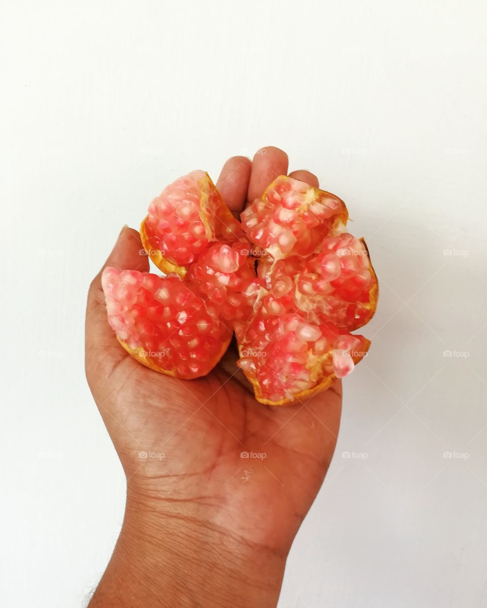 Studio shot of pomegranate on hand