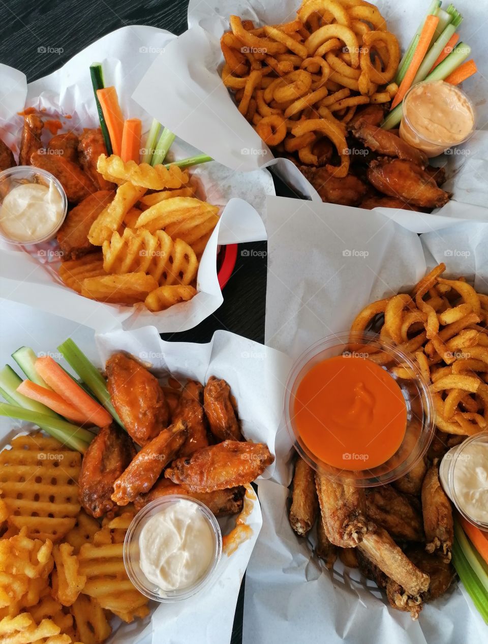 Chicken wings in a restaurant with deep-fried potatoes and various sauces. Very delicious!