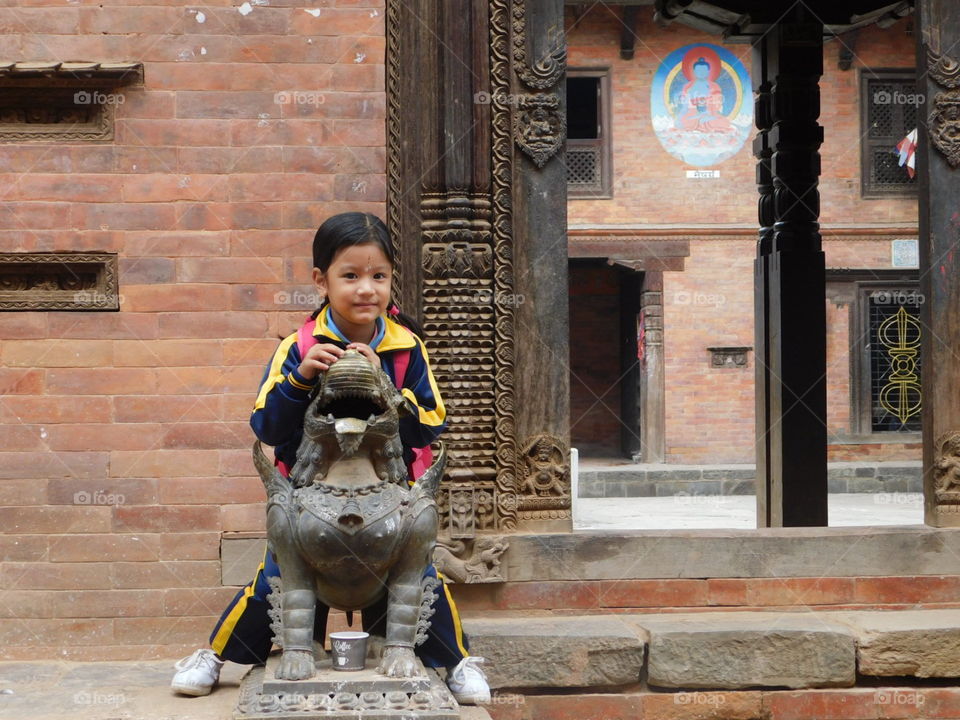 nepal girl sits on statue