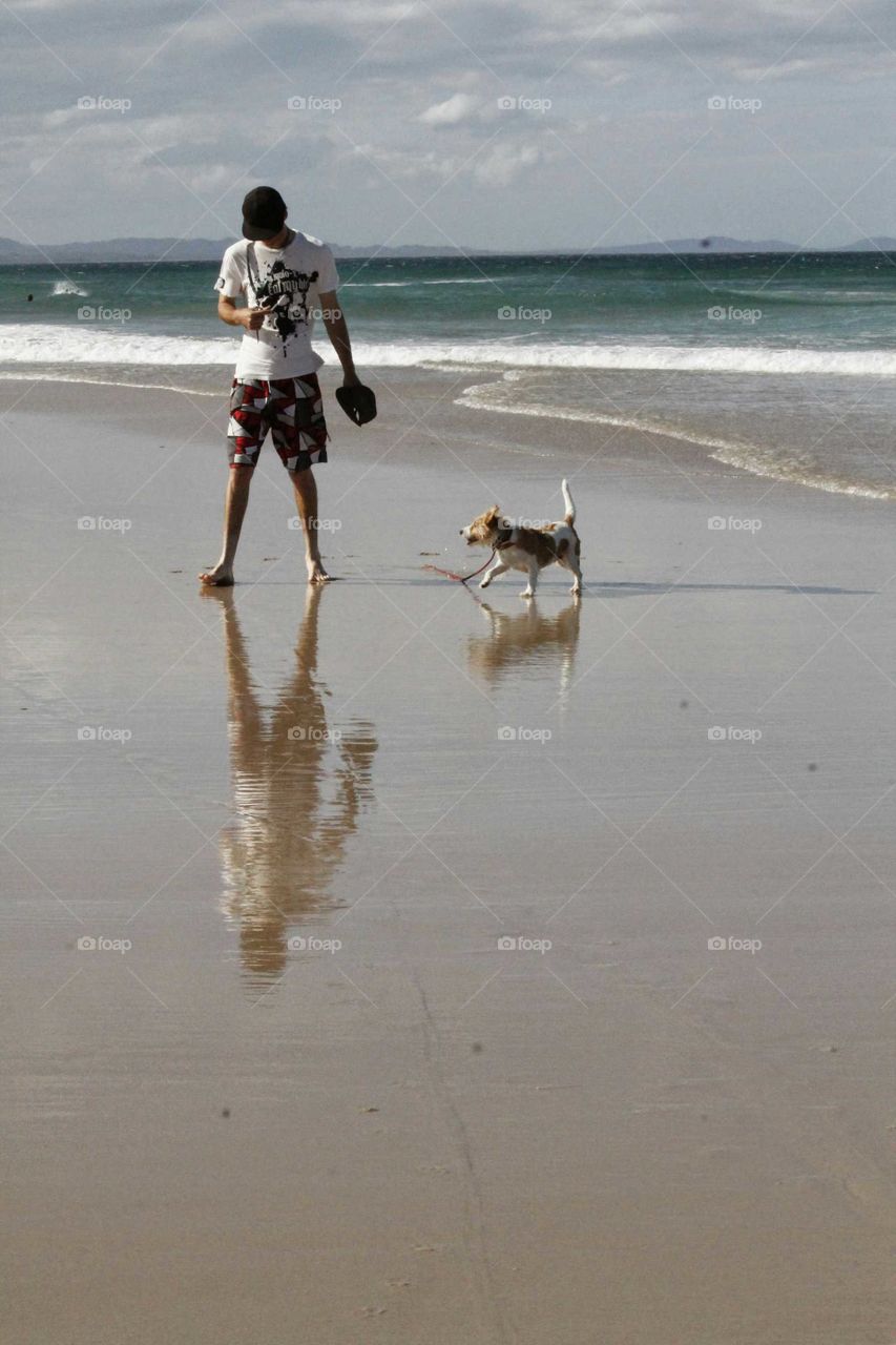 man and dog enjoying the beach