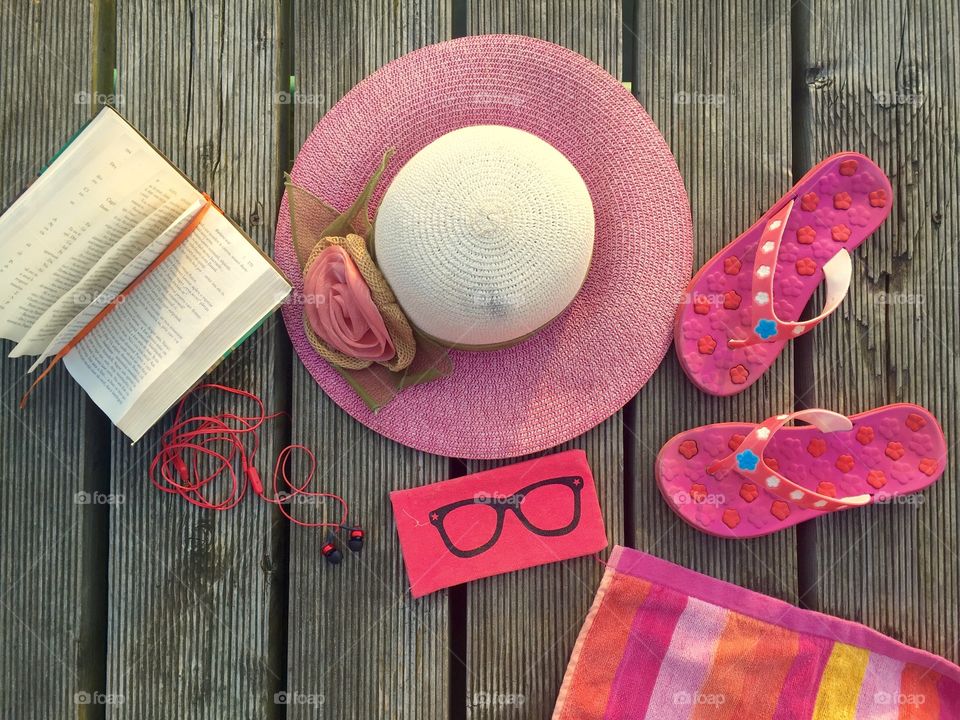 Pink flat lay summer items on wooden deck