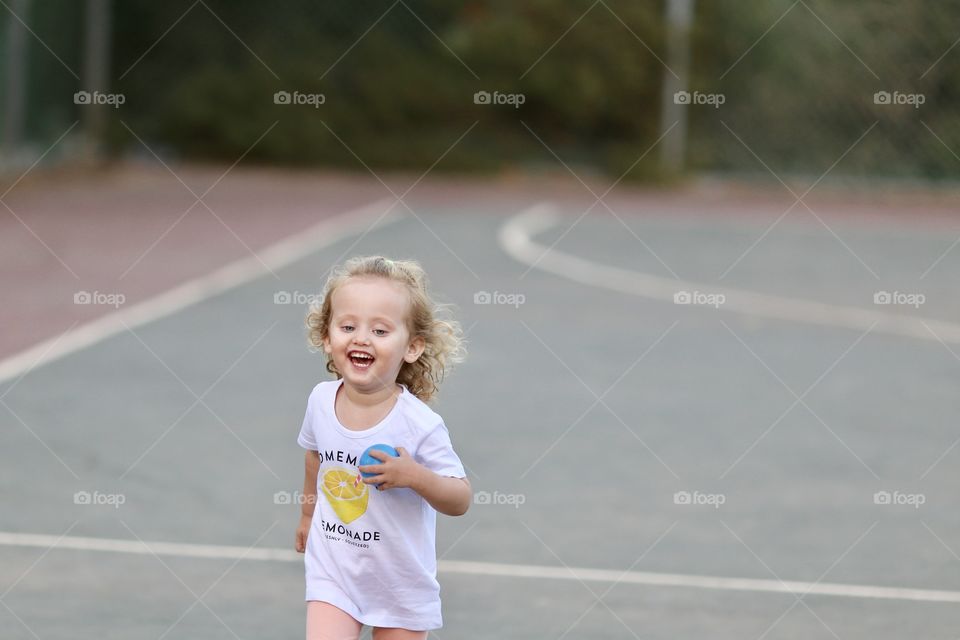 Girl with ball in her hand running on basketball field
