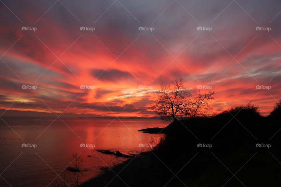 Sky is burning after sun sets for the night and red and black colors clash on dusk