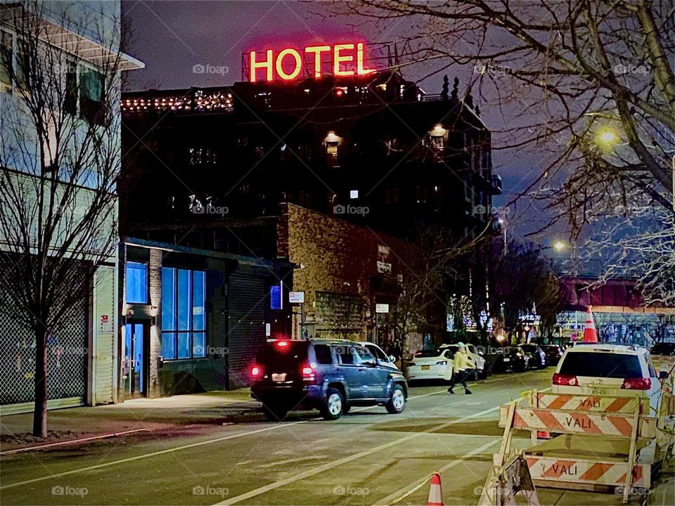 A nighttime Impression the of walking home to ascend and cross over on the „Pulaski Bridge“ on „Box St“ walking towards the „Pulaski Bridge“ at „Newtown Creek“. The „BOXHOUSE Hotel“ emblem on top pf the building.can clearly be seen. 2023. Hypnotic Pr