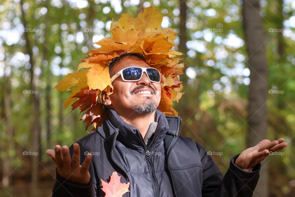 Happy middle-aged man in a leaves crown