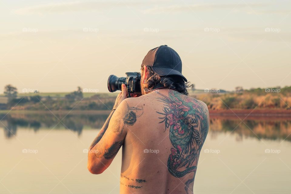 fotógrafo em represa no fim do dia