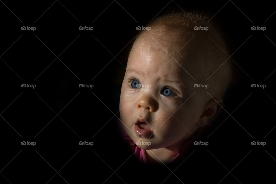 Close-up of a baby face on black background