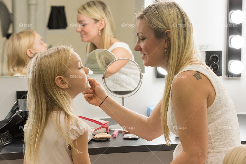 Mother styling her 6 years old doughter before a photoshoot.