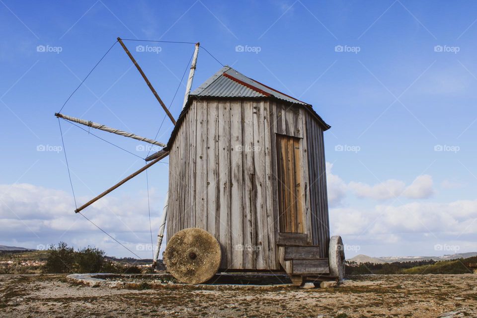 Old windmill in Ansião, Portugal. Blue and cloudy sky.