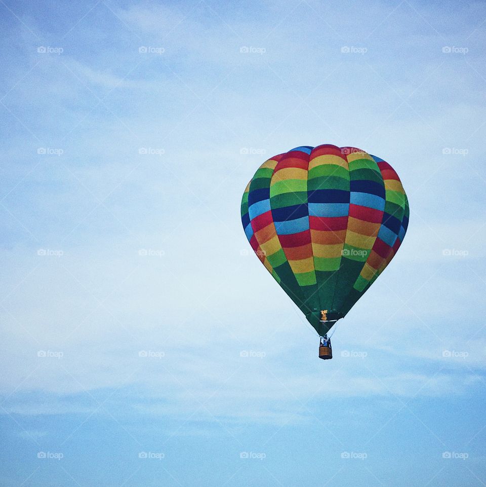 Hot air balloon in clear blue sky, sky with big hot air balloon, colorful balloon, multicolored balloon in sky, people taking a ride in balloon