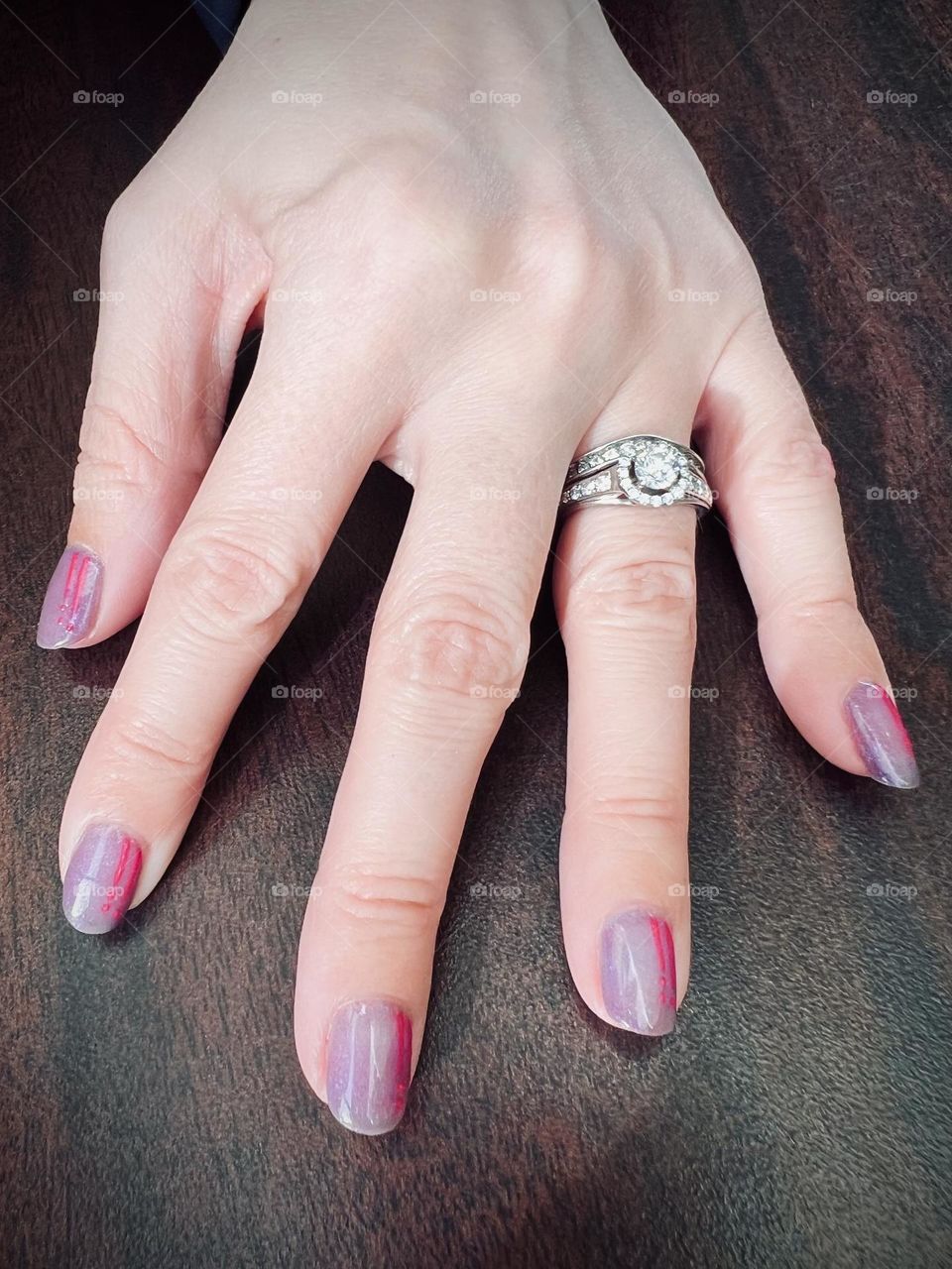 Closeup of my color-changing gel nail manicure and my wedding rings