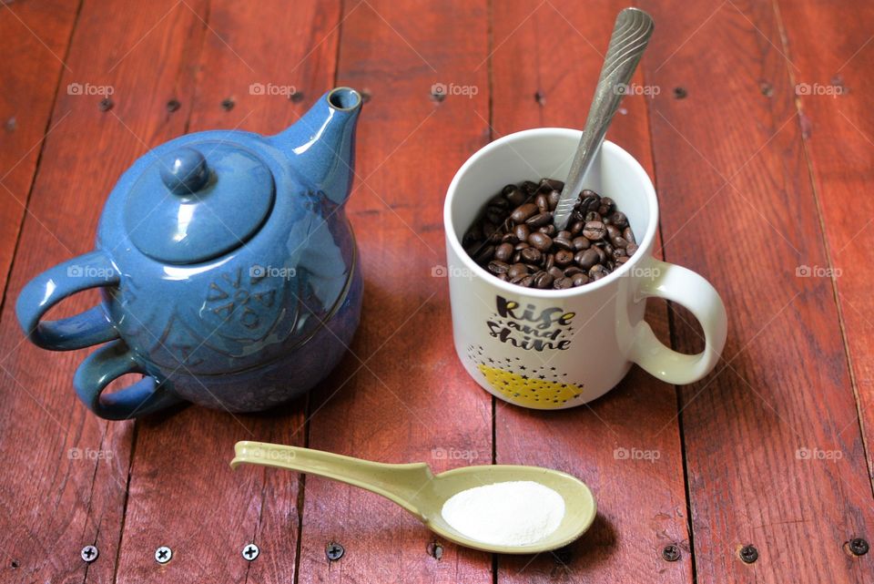 Morning coffee jolt with teapot and creamer on a wooden backdrop 