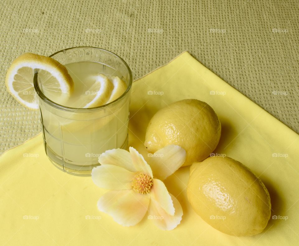 Yellow monochrome flat lay with lemons and lemonade 
