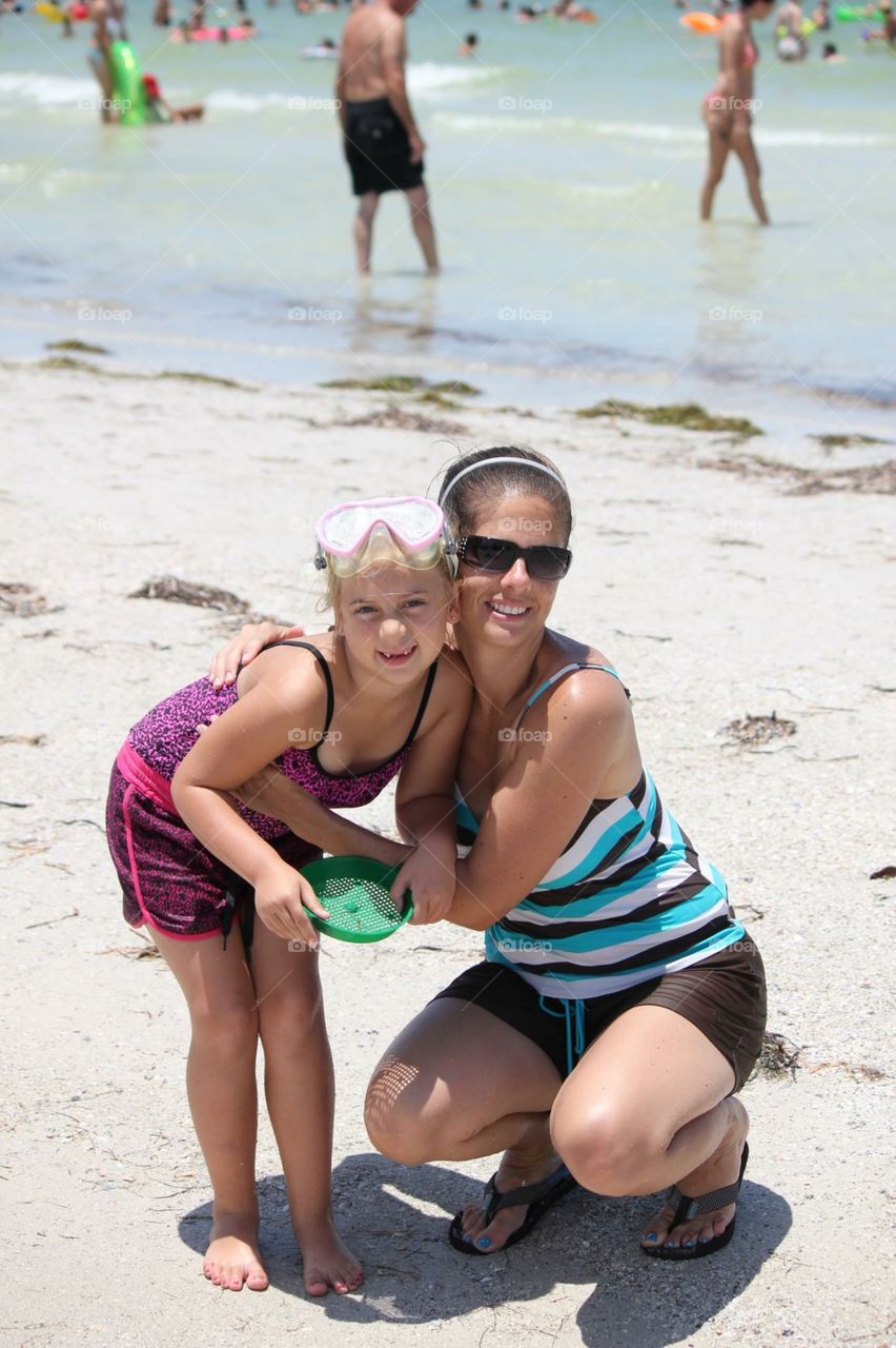 A day at the beach. Mom and daughter playing on the beach