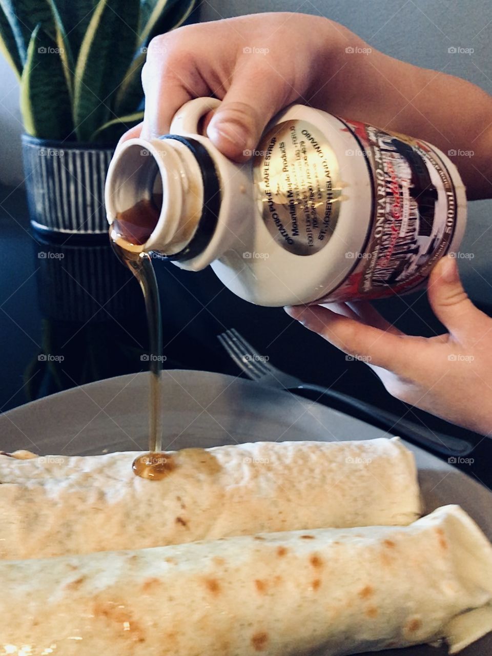 Pouring maple syrup on to a crepe
