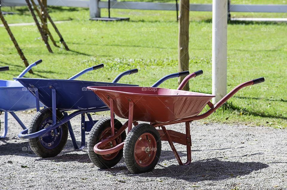 wheelbarrow carts colorful material on the floor.