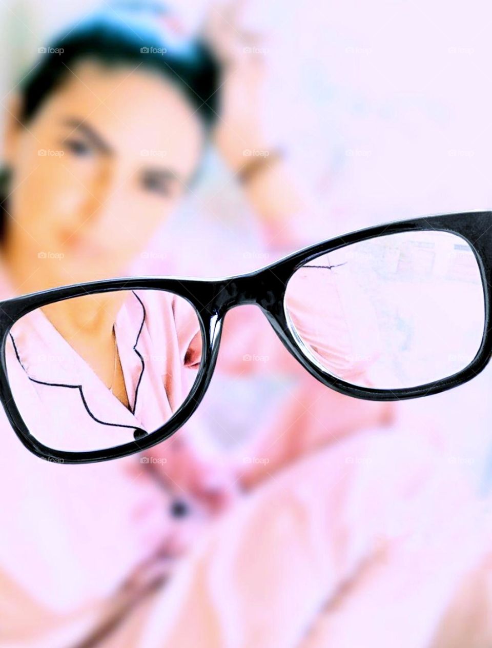 Barbie style.  Glasses in the foreground.  Through the glasses, a fuzzy image of a woman in pink pajamas
