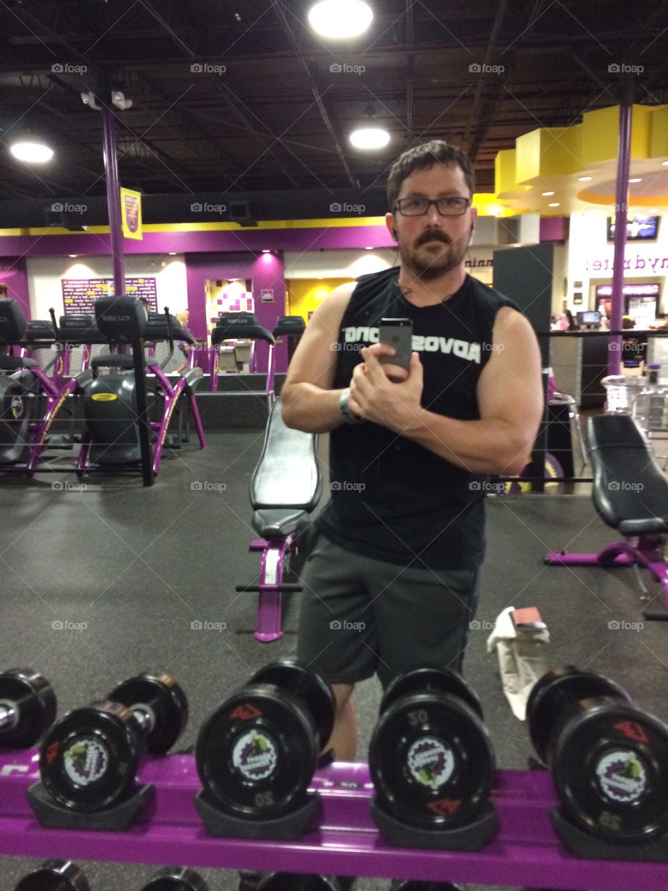 Man in gym holding cell phone