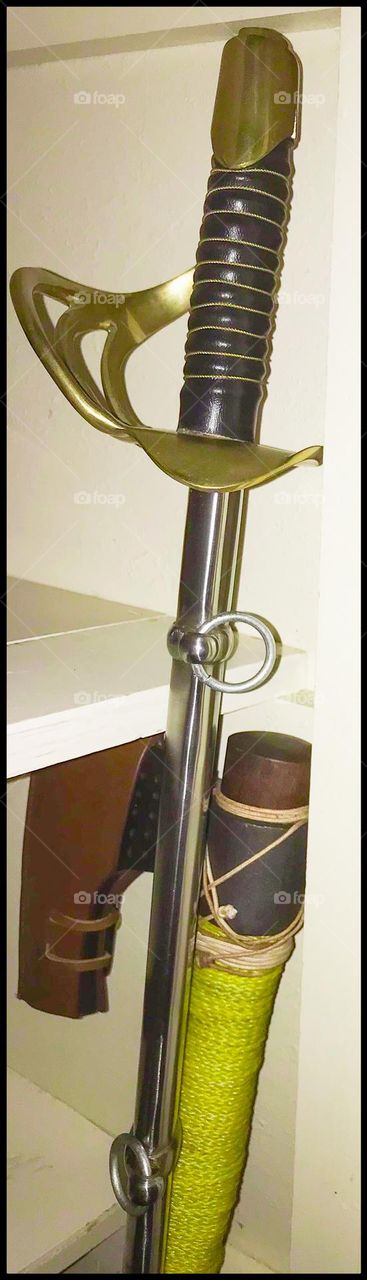 A battle-ready heavy cavalry sword and Norse ax safely stored in a closet that acts as a home armory.