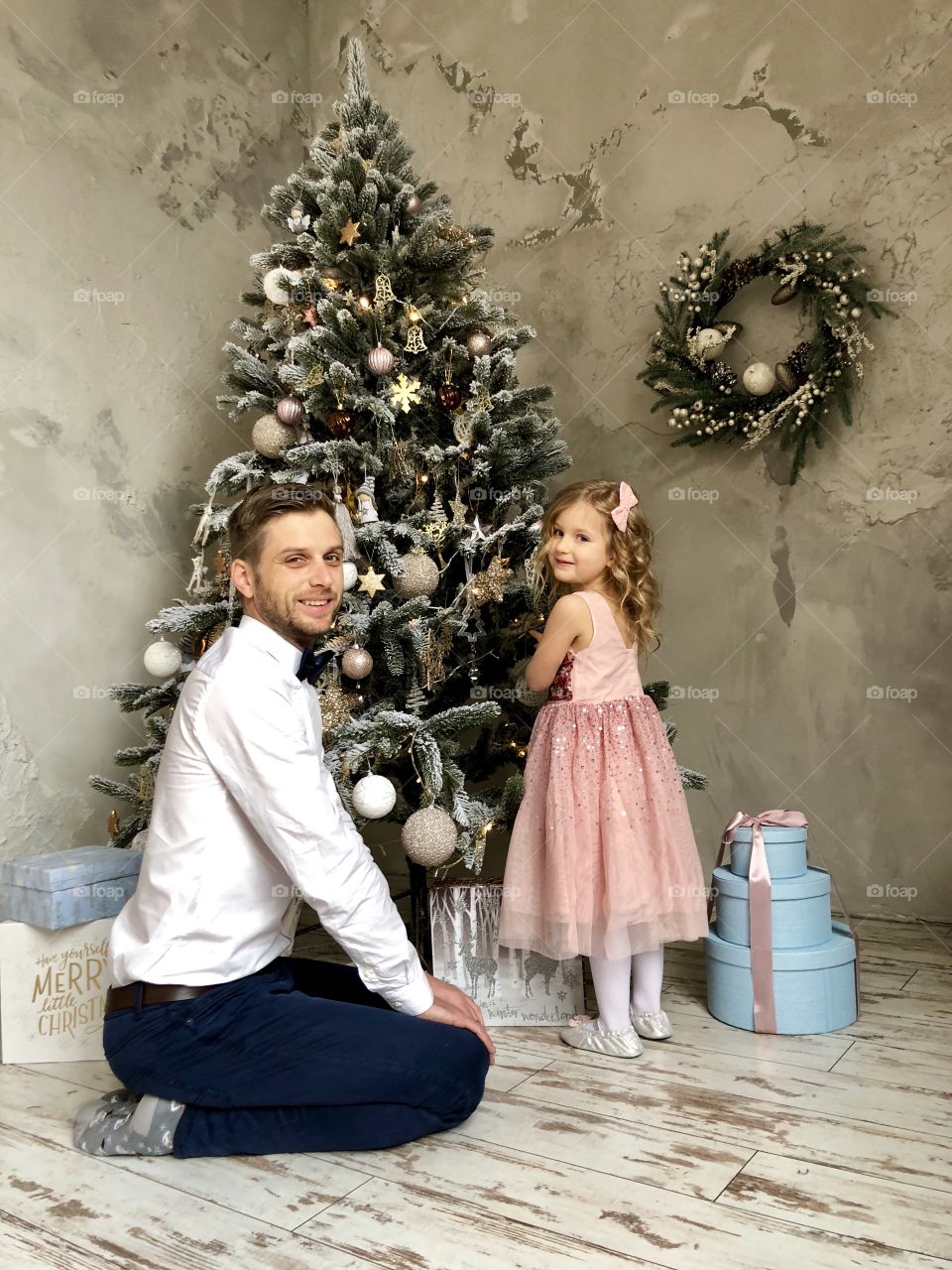 Father and daughter decorating Christmas tree.