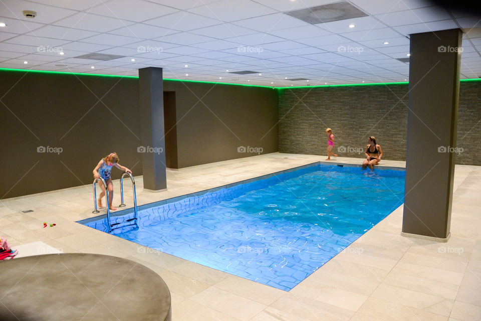 Family taking a swim in a swimming pool at a hotel in Denmark.