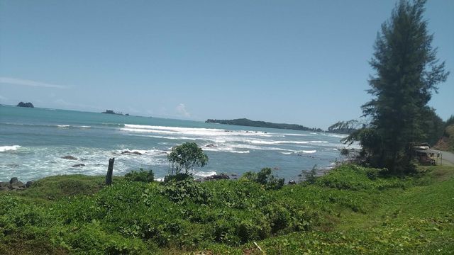 Sea view with amazing waves towards a beautiful beach plus amazing blue sky.