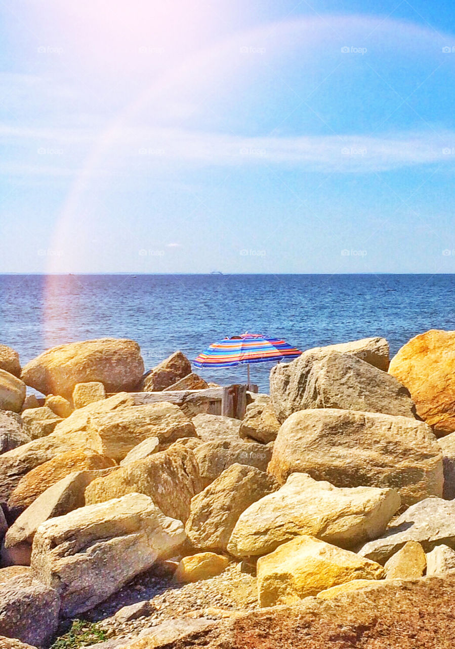 Walking the seawall..... Parasol thru the stones.