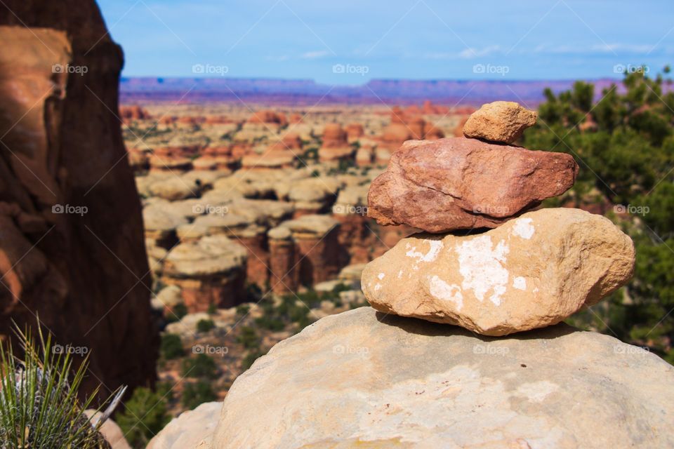 A cairn sits in front of a canyon landscape.