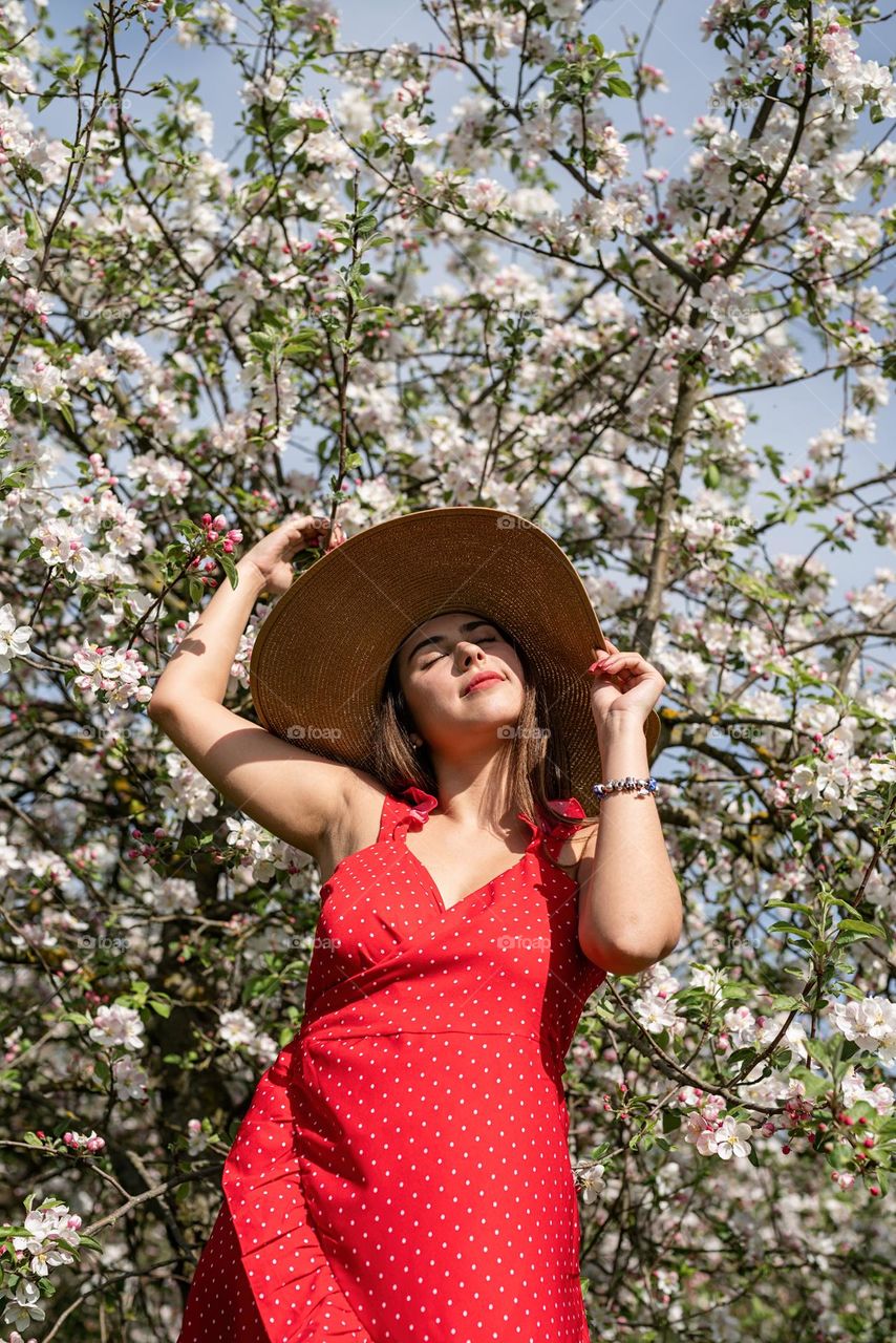 woman in red dress in apple blossom