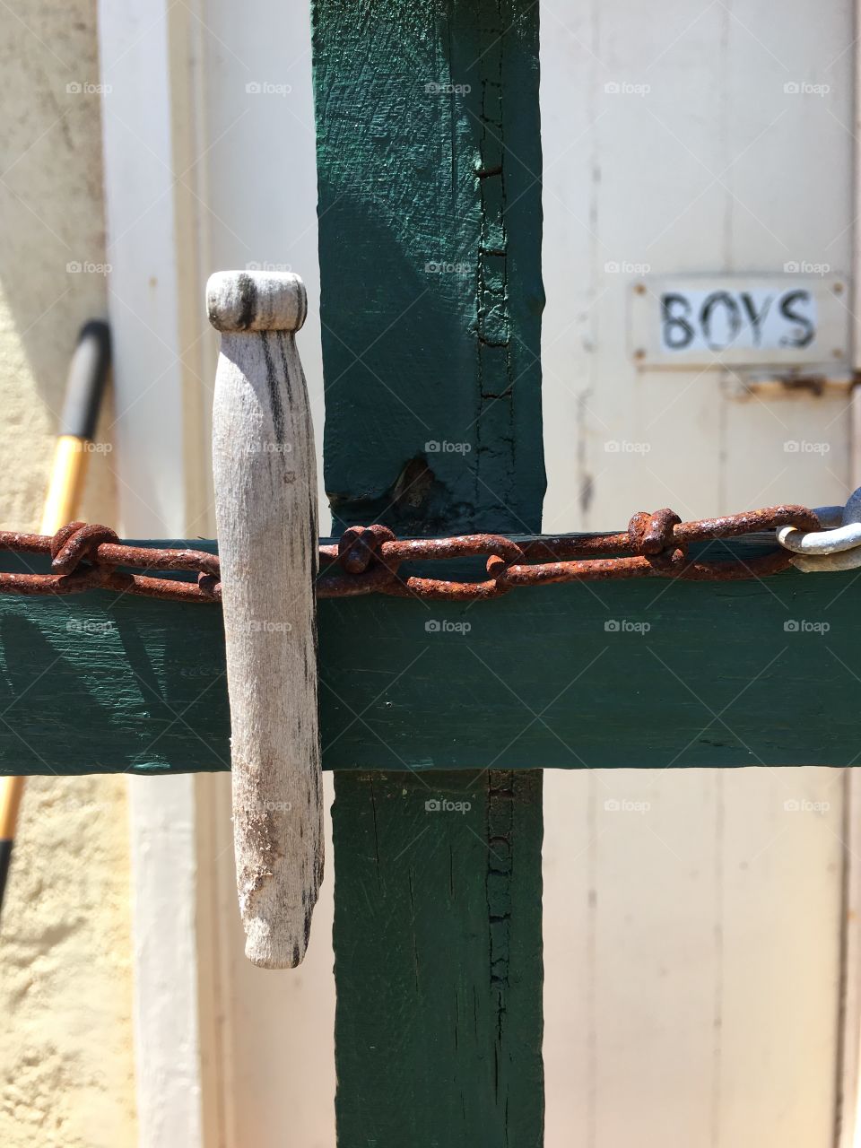 Antique wood clothespin clothes peg, closeup on old fence and rusted antique barbed wire 