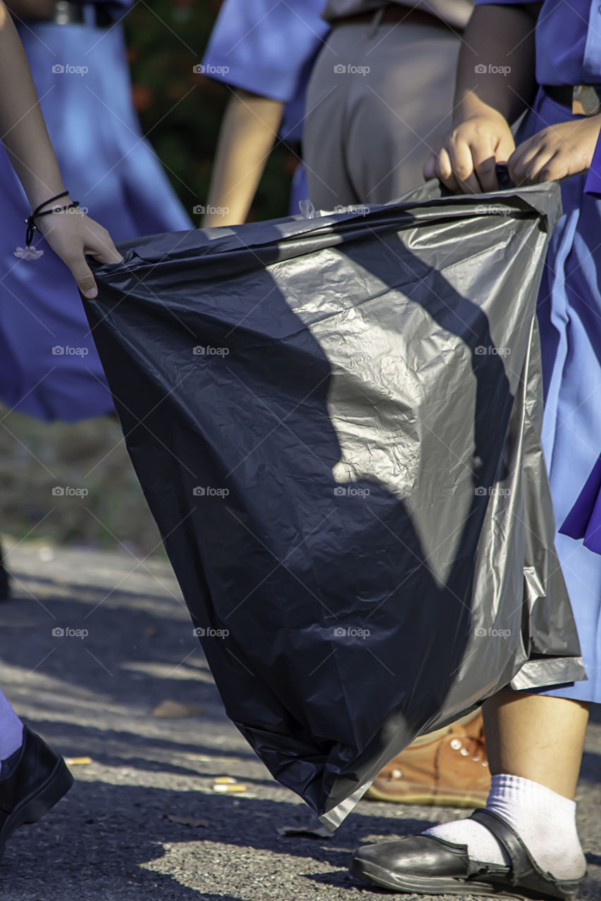 Hand Asean girl holding Black garbage bags.