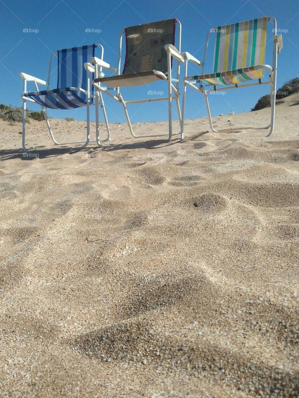 Chairs on peak of sands.