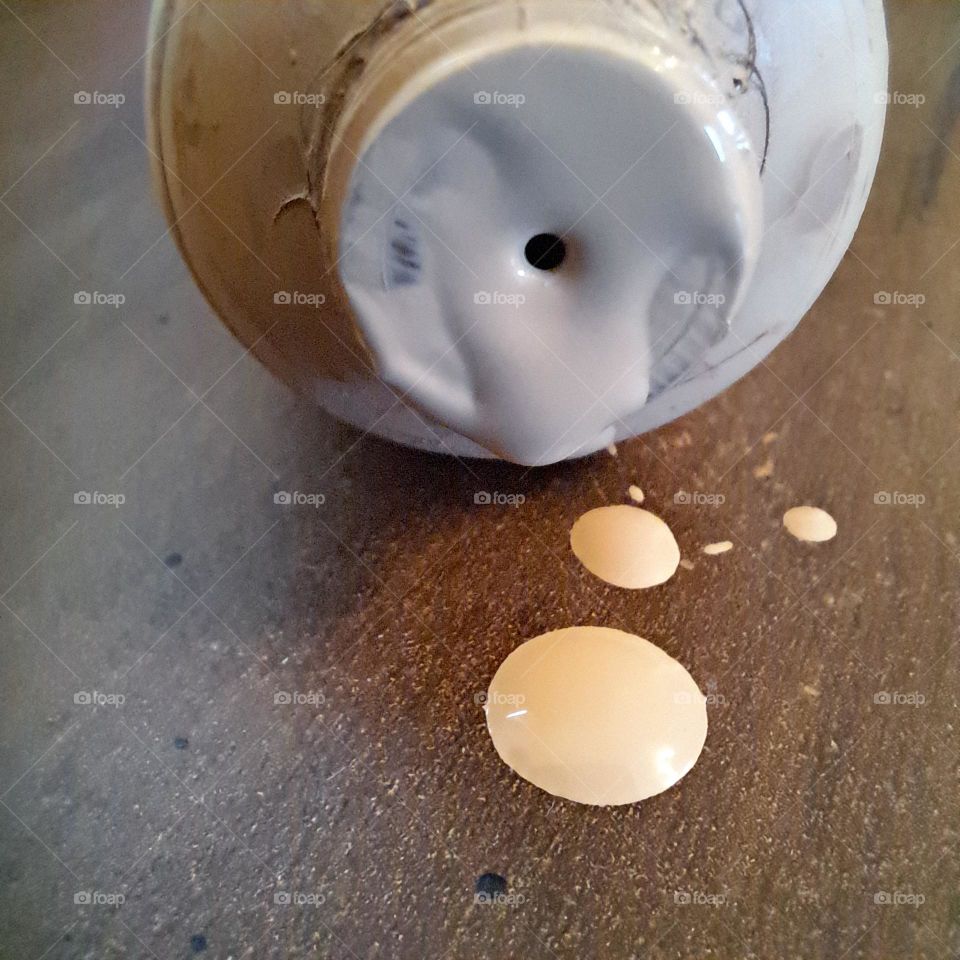 spilled foundation makeup droplets on wooden surface tube