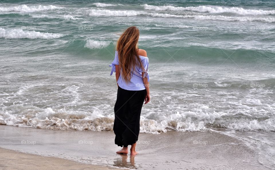 woman standing on the beach playa de muro on mallorca balearic island in spain - mediterranean sea vacation