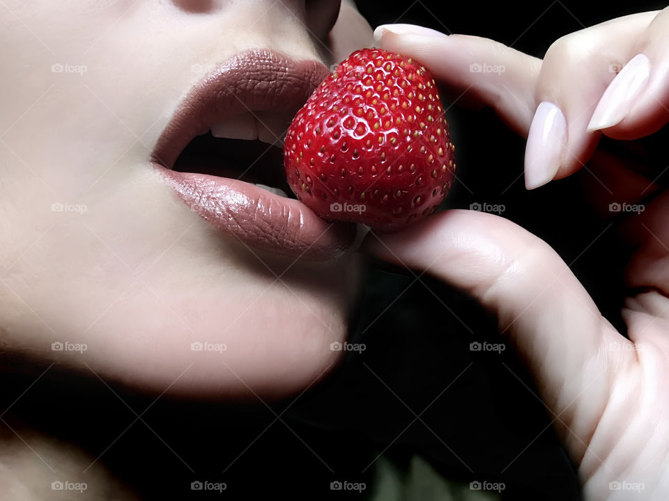Young woman eating strawberry 
