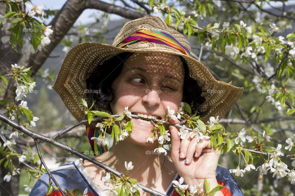 Woman biting tree flowering branch