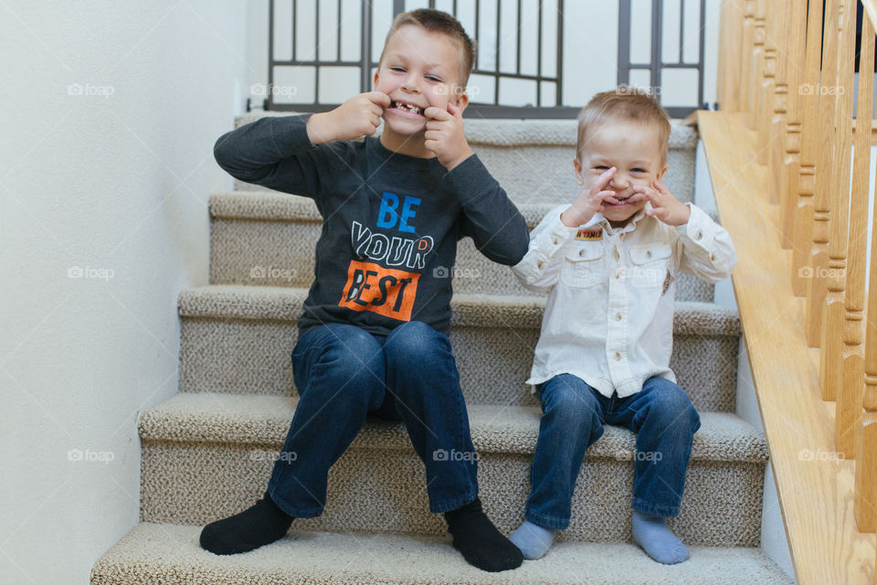 Silly boys sitting on stairs